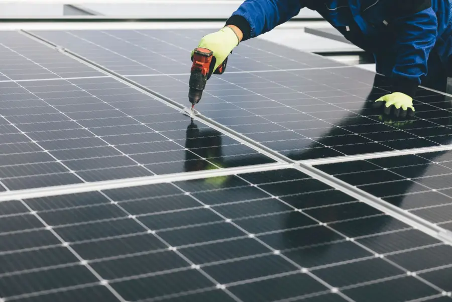 Technicien fixant un panneau photovoltaïque sur une structure de toiture